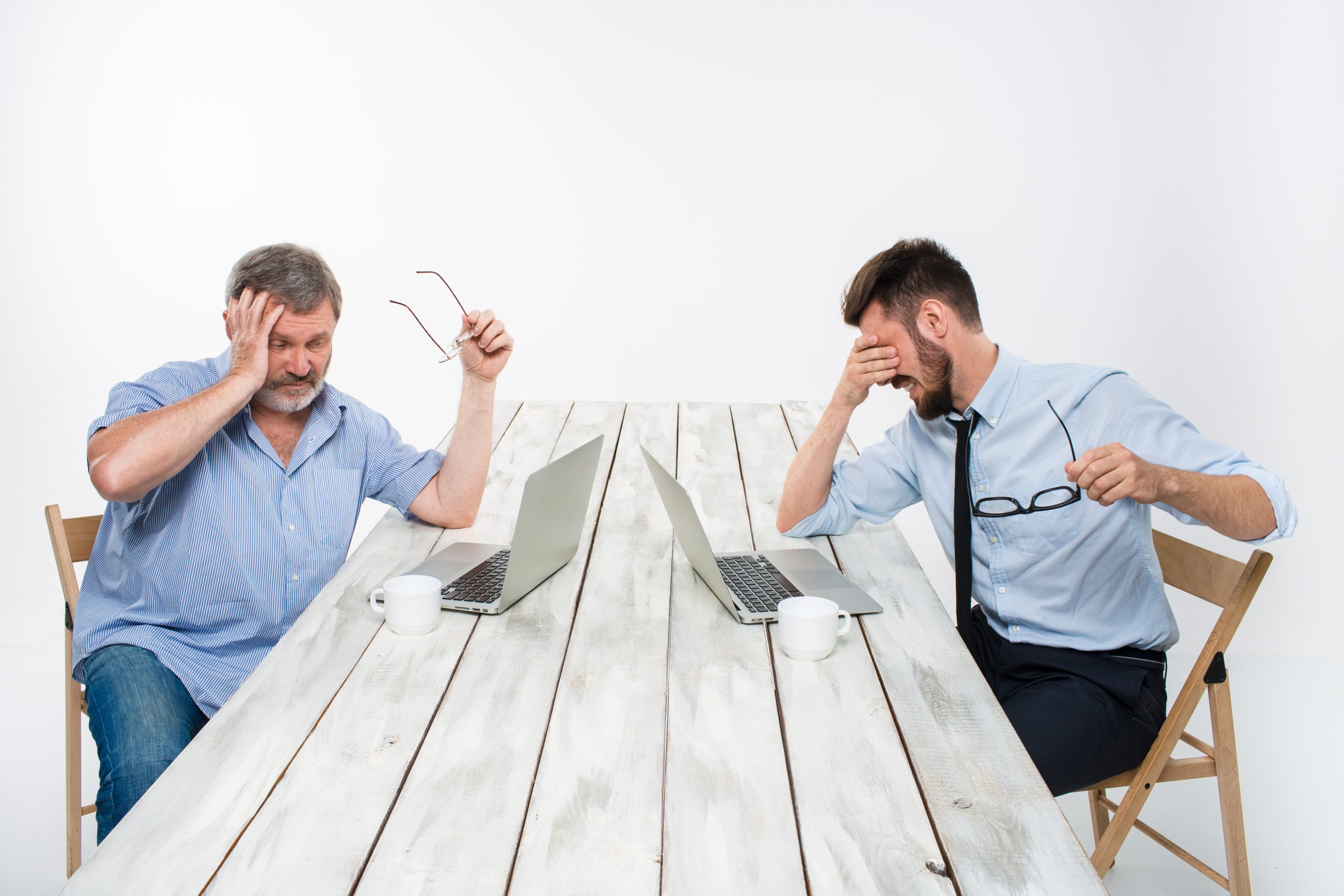 The two colleagues working together at office on white  background. both are looking at the computer screens. both very upset. concept of negative emotions and bad news